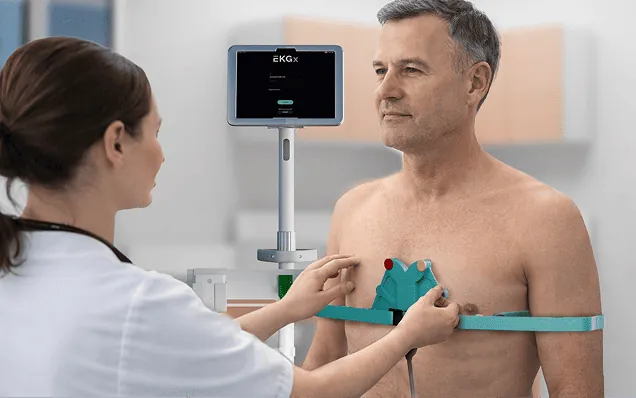 Clinician fitting the EKGx belt on a seated patient